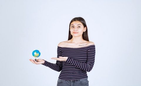 young woman striped shirt holding mini globe pointing it 144627 53820